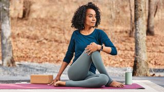 Woman doing yoga wearing Fitbit Charge 5 fitness tracker