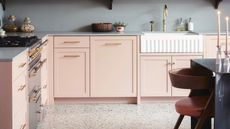 Pink kitchen cabinets with gold tap and ornaments