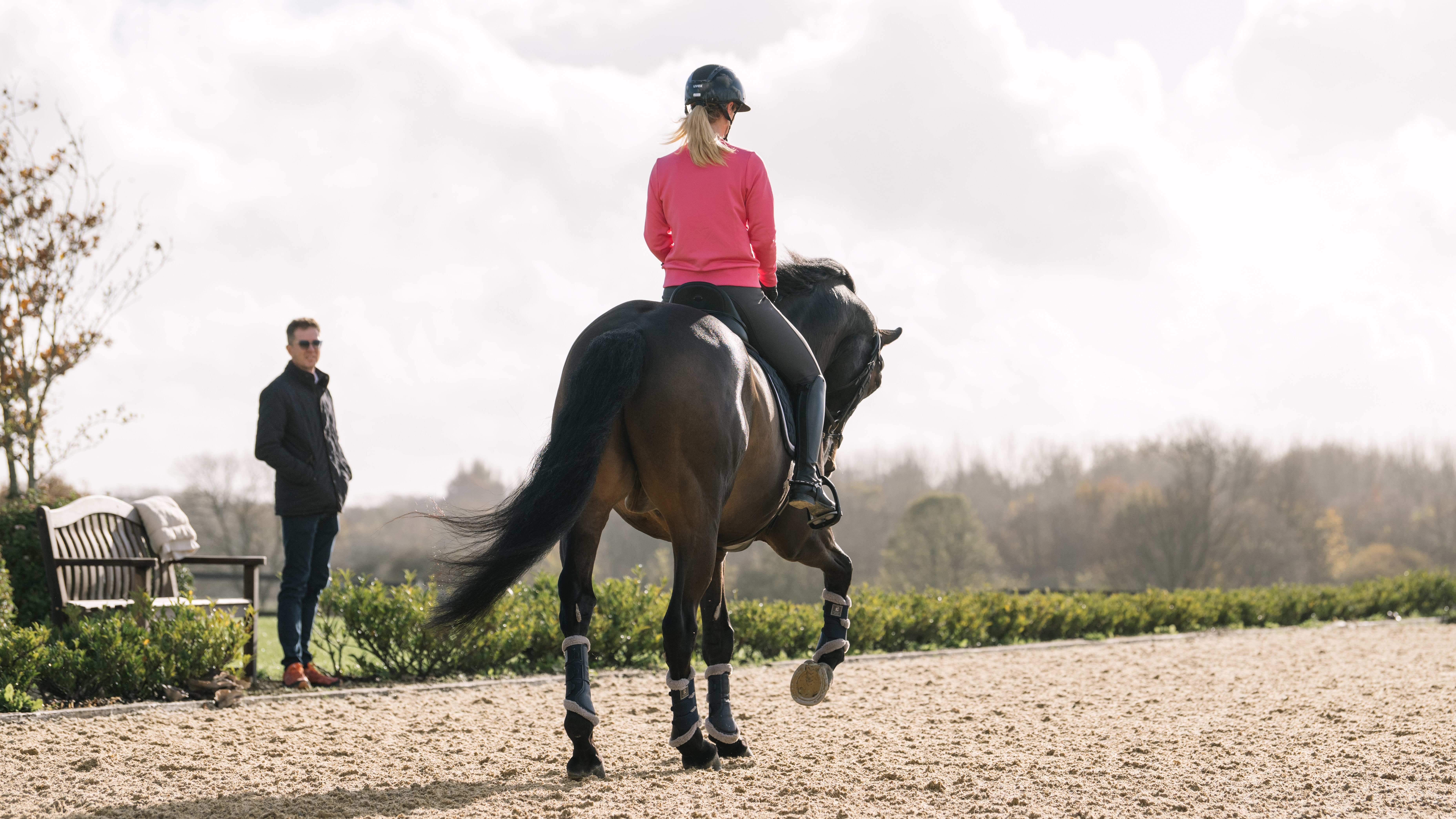 Laura Tomlinson practising riding a centre line in an arena, looked on by an assistant