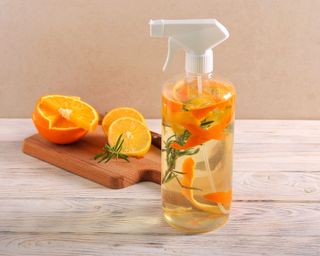 Homemade citrus spray with half-cut citrus fruits in the background