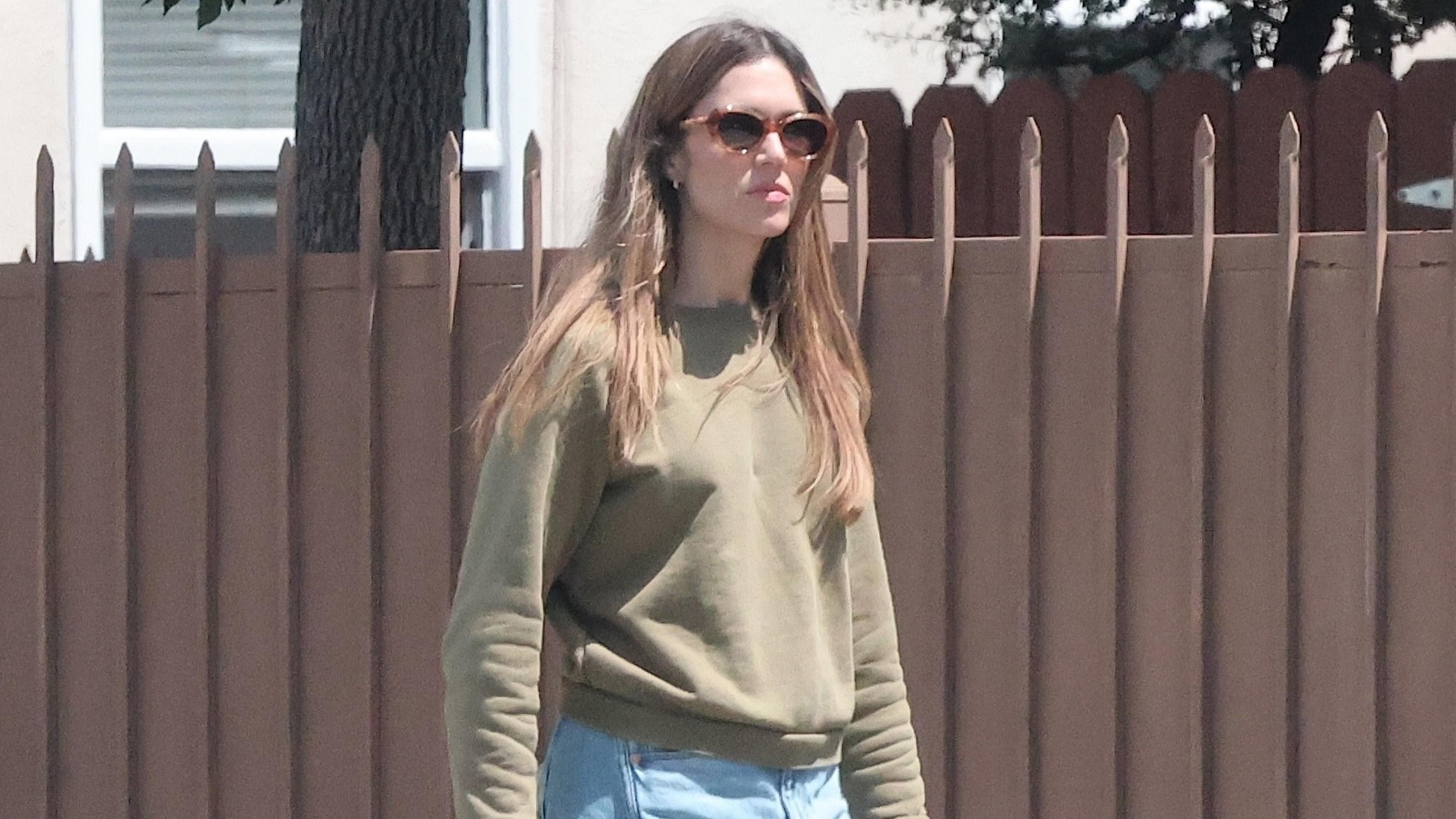 Mandy wears a green sweater and jeans.