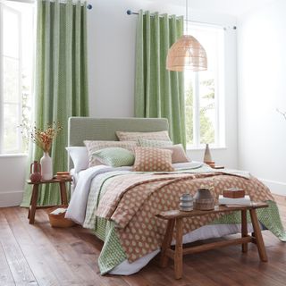 bedroom curtain mistakes, green and white bedroom with rust throw, green bedding, rustic stool and bench, wooden floor, pale green bed