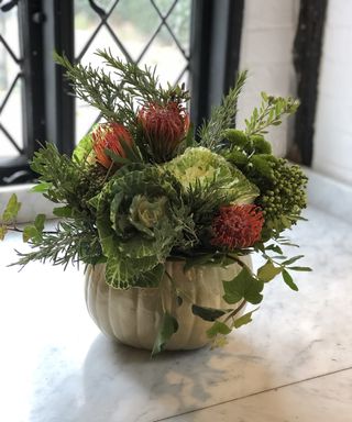 DIY Pumpkin vase idea with Cabbage Brassica flower and Dahlias and Spider Mum Flowers. Mint Chrysanthemum on kitchen worktop