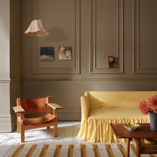 Craig & Rose Lucienne Olive and Jarosite from 1829 Vintage Collection used in a living room with a yellow ruffled sofa