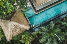 Woman enjoying alone in luxury swimming pool, drone view from above