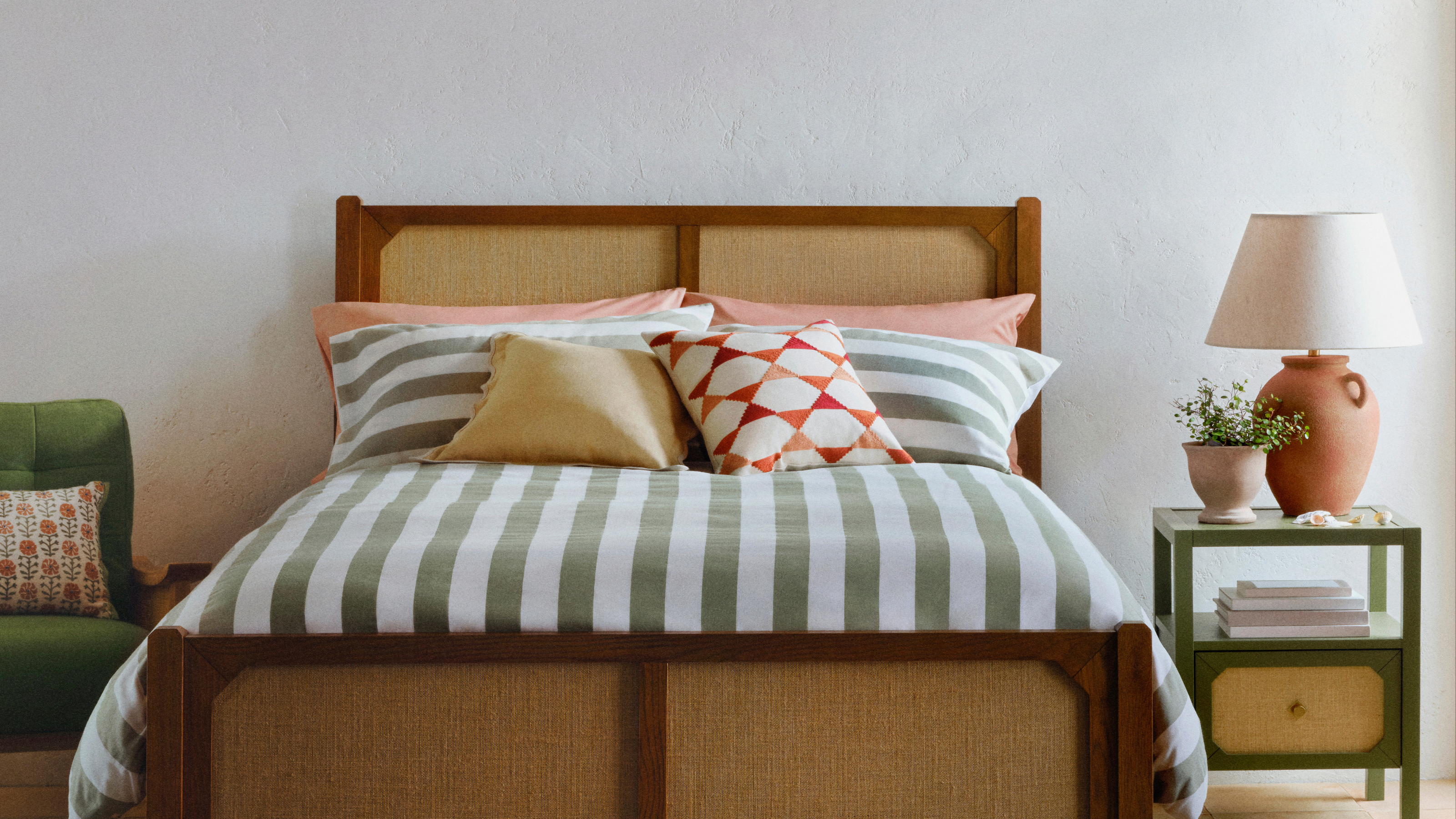 Green striped bedding on wooden bed.