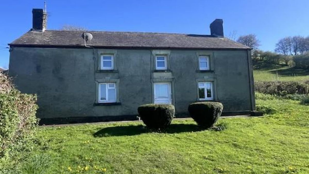 An unspoilt two tiered grey farmstead with attaching barns