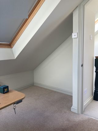 An attic room with a skylight and a small alcove