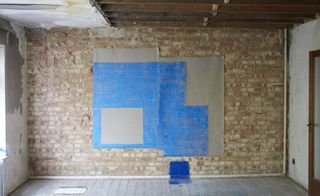 Exposed brick wall with paper hanging, printed using blue paint