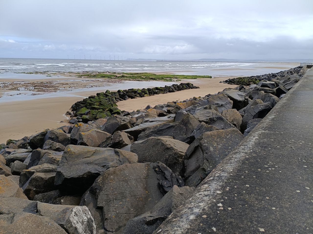 Rocky beach at low tide under a cloudy sky