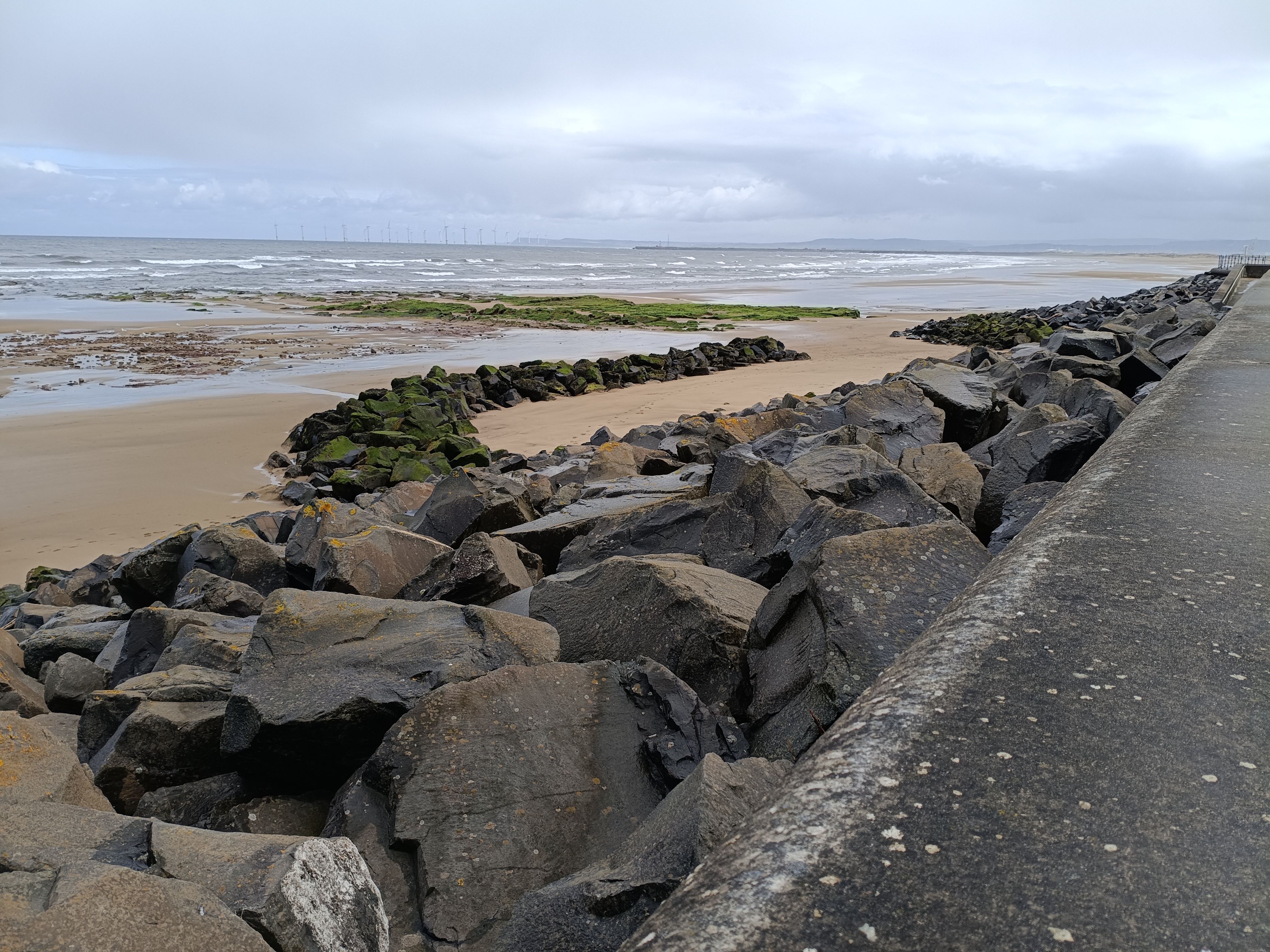 Rocky beach at low tide under a cloudy sky