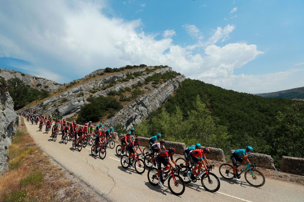 VILLADIEGO SPAIN AUGUST 03 A general view of Ruben Guerreiro of Portugal and Team EF Education Easypost Green Points Jersey Tao Geoghegan Hart of United Kingdom and Team INEOS Grenadiers Hermann Pernsteiner of Austria and Team Bahrain Victorious Stefan De Bod of South Africa and Team Astana Qazaqstan David De La Cruz Melgarejo of Spain and Team Astana Qazaqstan Omar Fraile Matarranz of Spain and Team INEOS Grenadiers Yukiya Arashiro of Japan and Team Bahrain Victorious Andrey Amador Bikkazakova of Costa Rica and Team INEOS Grenadiers Vadim Pronskiy of Kazahkstan and Team Astana Qazaqstan and the peloton compete passing through a landscape during the 44th Vuelta a Burgos 2022a Stage 2 a 158km stage from Vivar del Cid to Villadiego on August 03 2022 in Villadiego Spain Photo by Gonzalo Arroyo MorenoGetty Images