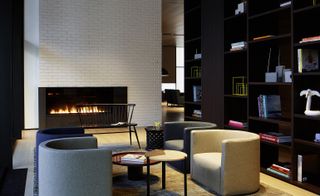 A view of a lounge area featuring a fire and chairs