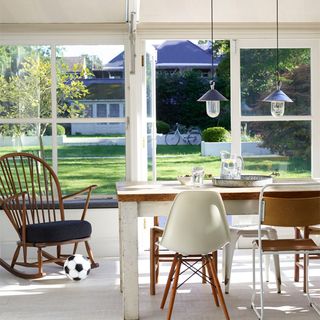 dinning area with dinning table and chairs outdoor view and glass wall