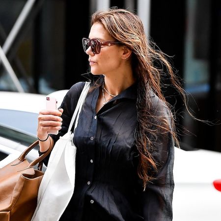 Katie Holmes wearing a sheer black shirt, black trousers, and burgundy ballet flats in New York City August 2024