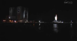 The space shuttle Endeavour casts a shadow on NASA's enormous Vehicle Assembly Building as it rolls to the launch pad for its final mission STS-134 on March 10, 2011 at the Kennedy Space Center in Florida. Endeavour is slated to launch on the mission on A