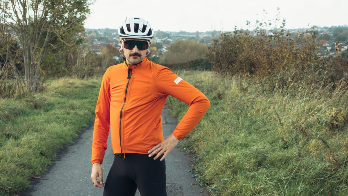 A white man in a orange rain jacket