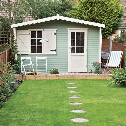 sloping roof house with white door and grass lawn