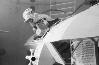 Ronald E. Evans conducts underwater EVA training. He is seen here in a water tank inspecting equipment while wearing a spacesuit.