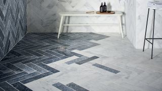 herringbone marble wall and floor tiles in walk in shower
