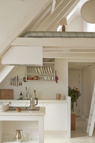 White kitchen flooded with light and wooden and silver utensils