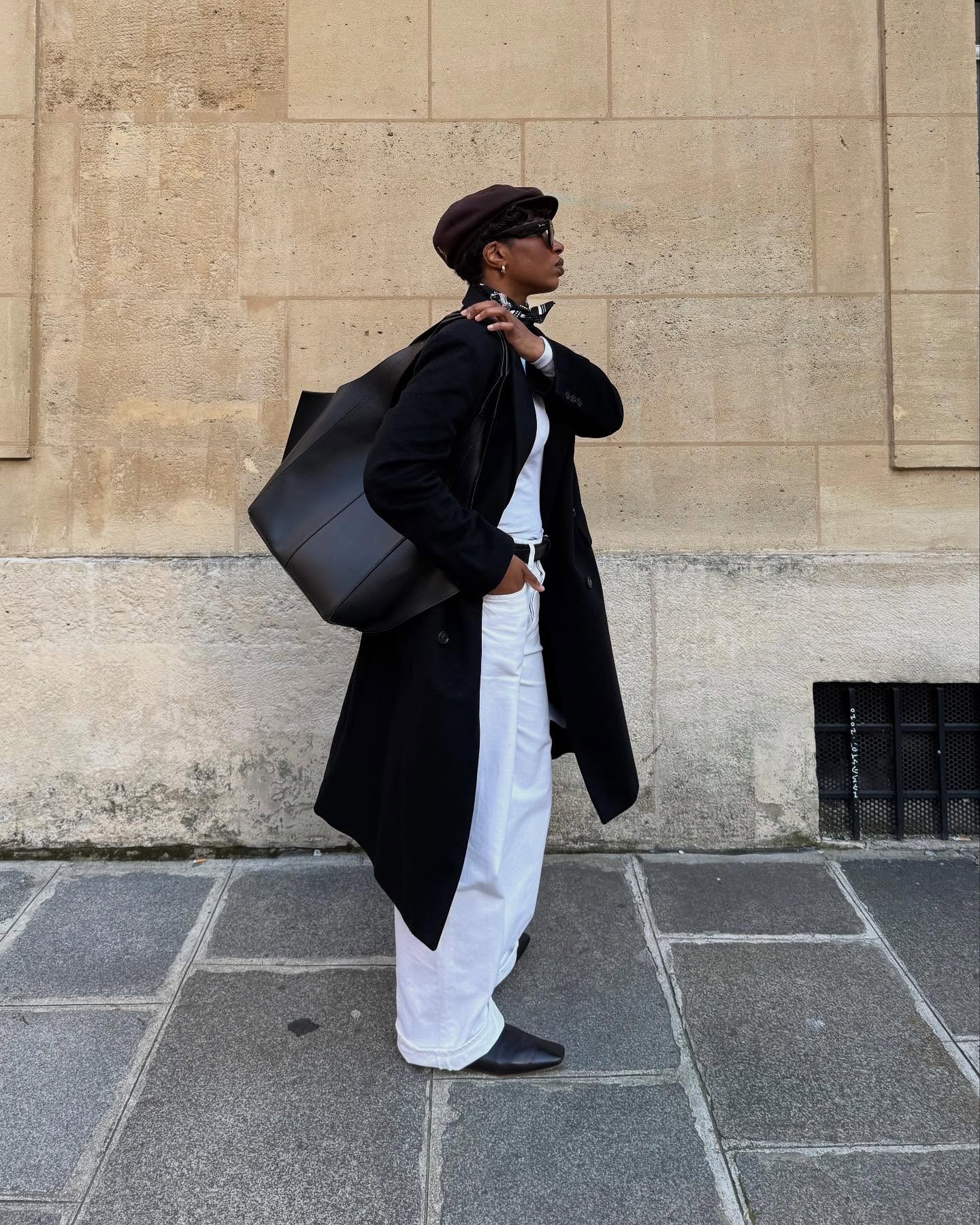 Influencer @thevisuelofgrace wears white jeans with black boots, a black wool coat and a black leather bag.