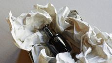 perfume bottle in unwrapped paper packaging