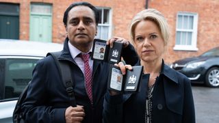 Jess and Sunny on a doorstep showing their police badges