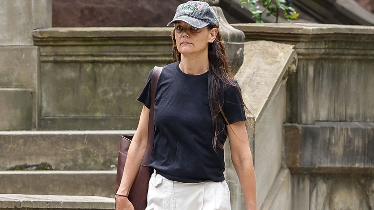 Katie Holmes wears one of her classic outfit formulas, white wide-leg pants and a relaxed tee, while walking around New York City