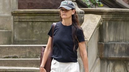 Katie Holmes wears one of her classic outfit formulas, white wide-leg pants and a relaxed tee, while walking around New York City