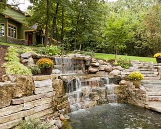 large waterfall feature and pond in a backyard rock garden