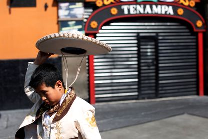A mariachi child fixes his hat during a pilgrimage to the Basilica of Our Lady of Guadalupe to celebrate Santa Cecilia, patron of musicians in Mexico City, Mexico.
