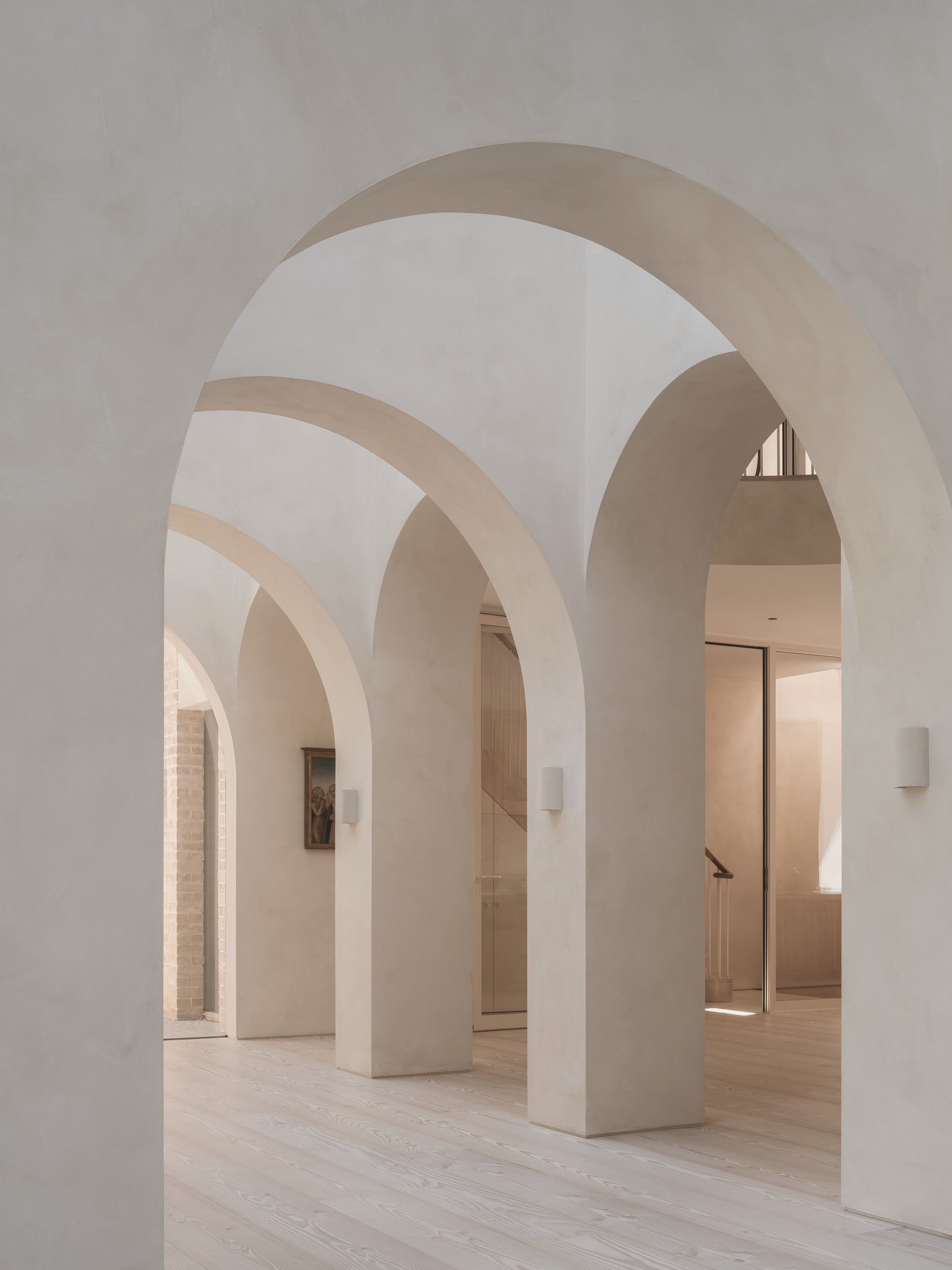 arched hallway extension with travertine floors and plaster walls