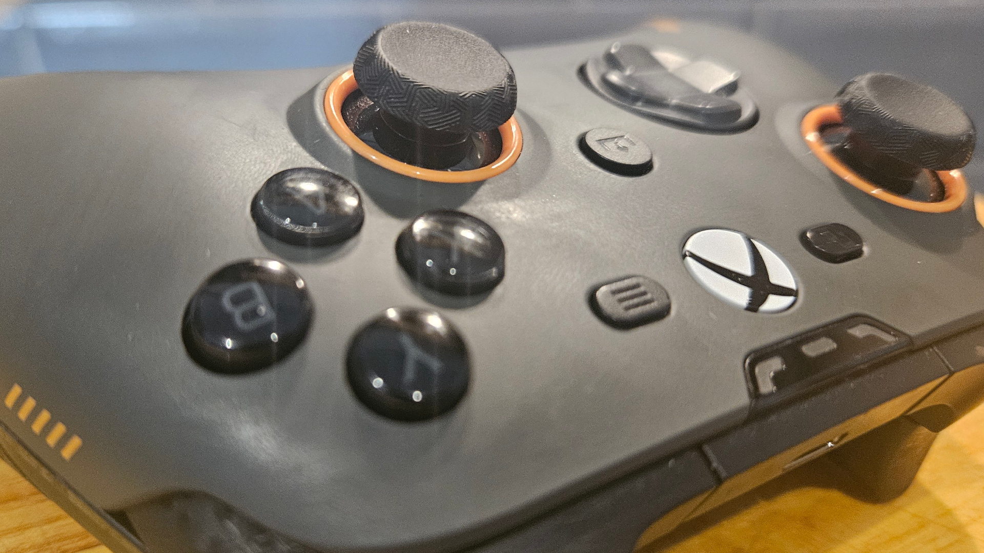 A photograph of a grey Scuf Valor Pro not plugged in, on a wooden surface