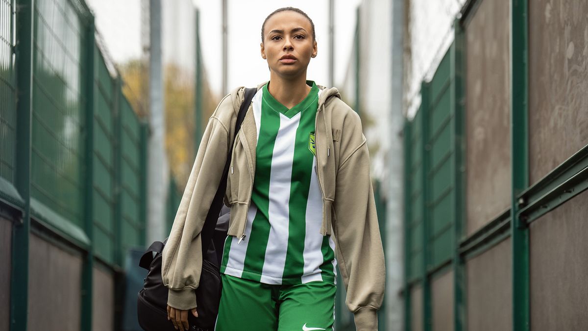 Abbie Hern's Gemma wearing a soccer outfit and jacket, and carrying a sports bag, in Ted Lasso season 4
