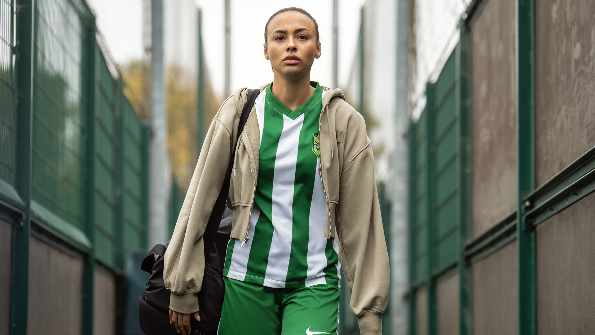 Abbie Hern's Gemma wearing a soccer outfit and jacket, and carrying a sports bag, in Ted Lasso season 4