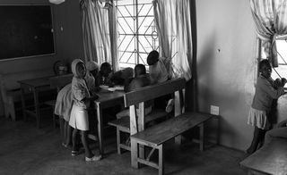 black and white photo of children around a table