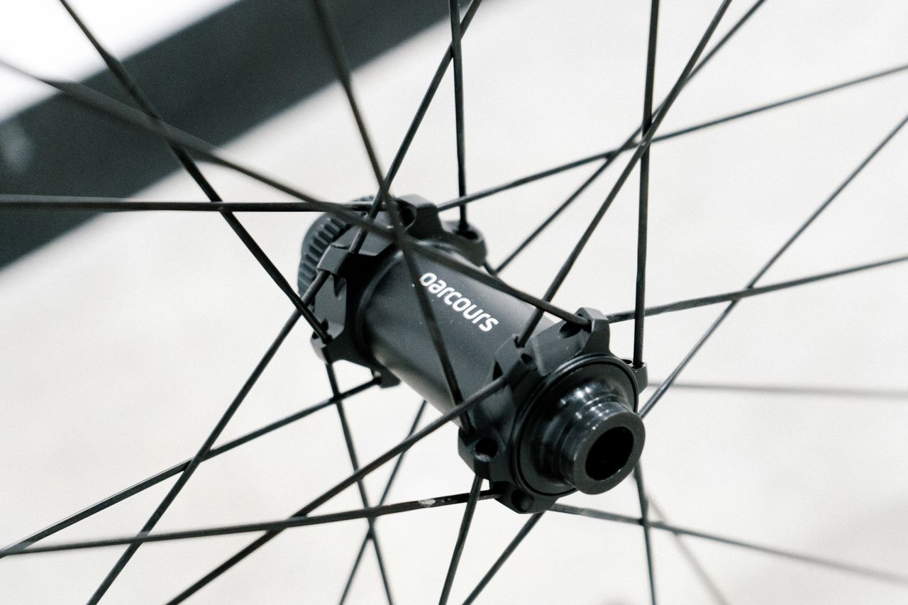 An aero road wheel stands against a white wall
