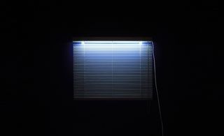 Dark room with window and white Venetian blind
