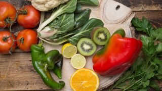 various fruits and vegetables high in vitamin c on a wooden board 