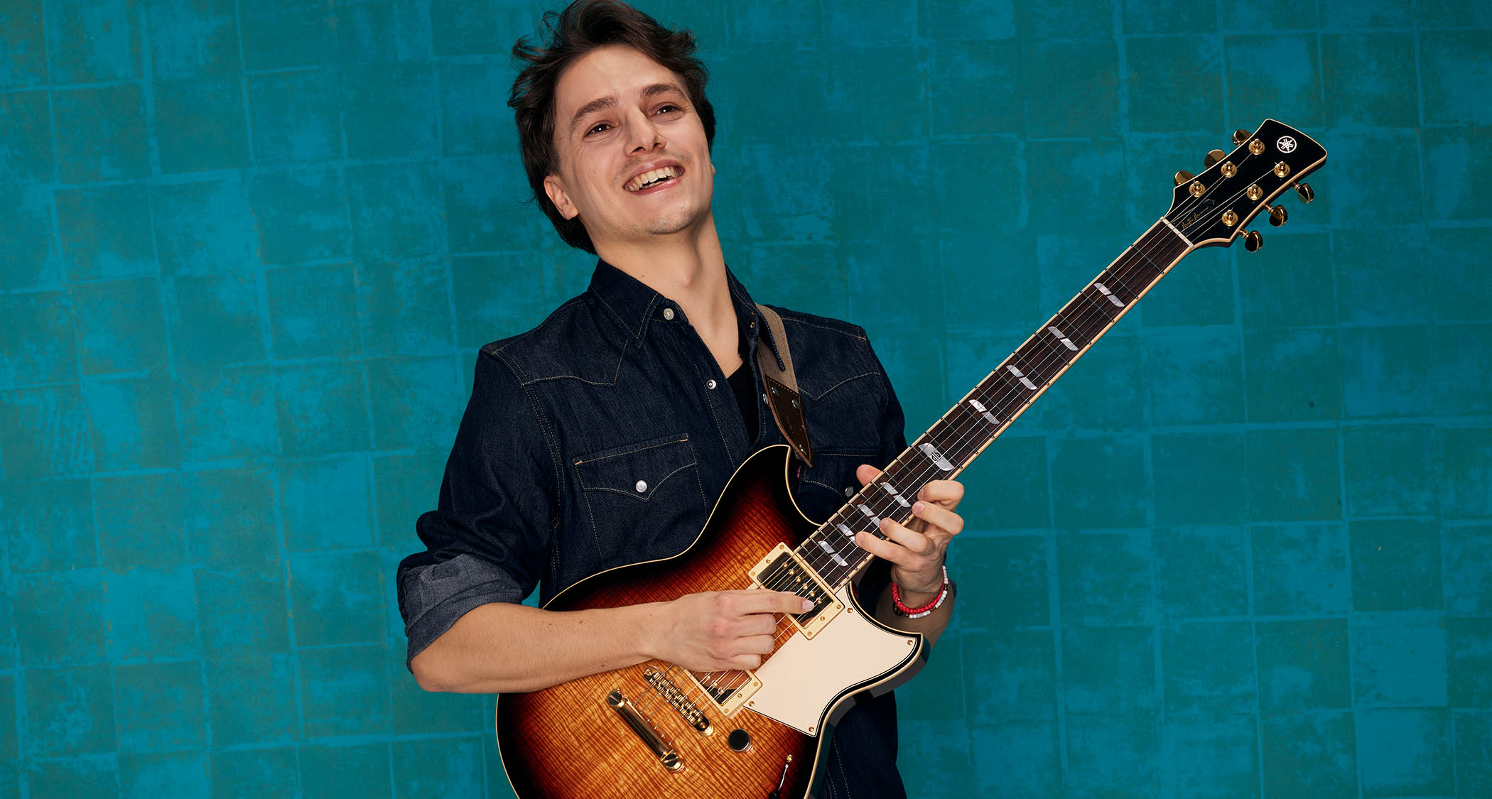 A studio portrait of Matteo Mancuso with his Yamaha Revstar