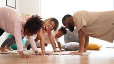 Family of man, woman and two girls exercising together, smiling