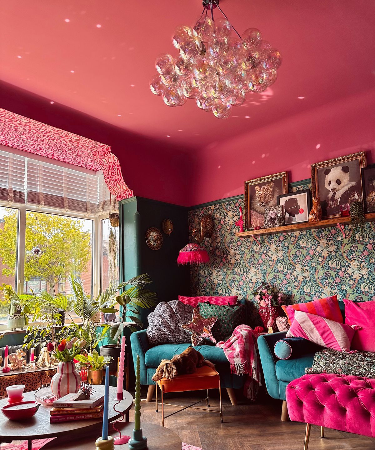 iridescent bubble ceiling light in room with pink painted ceiling, floral wallpaper and lots of seating and decorative items