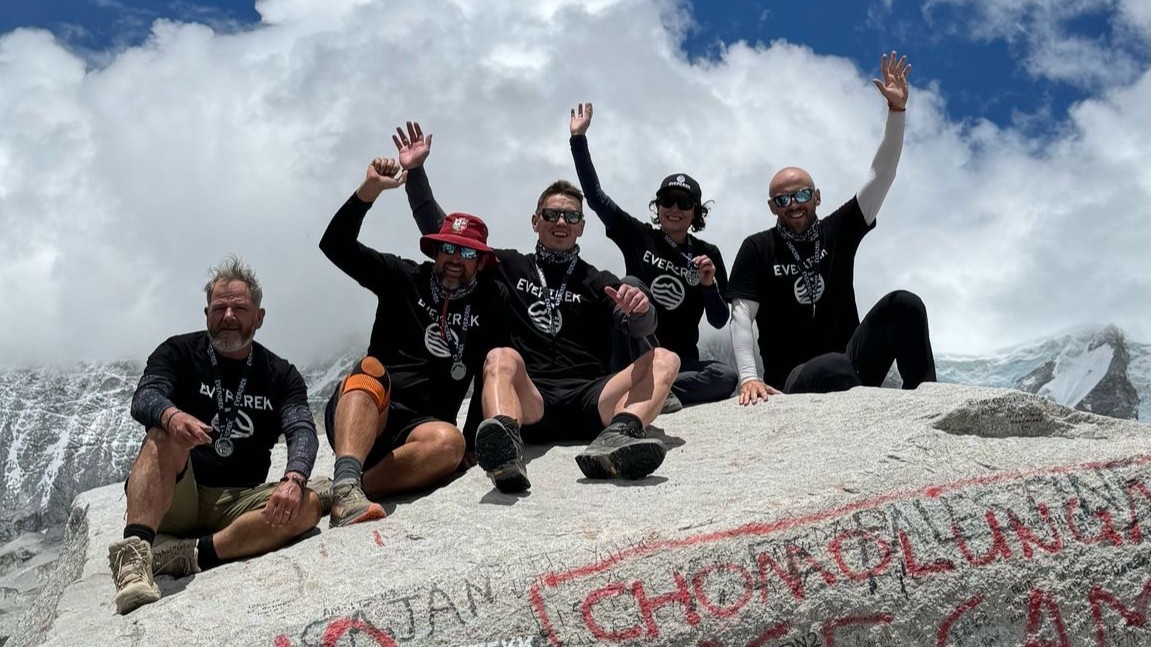 Julia Clarke and the EverTrek team on a boulder at Everest Base Camp