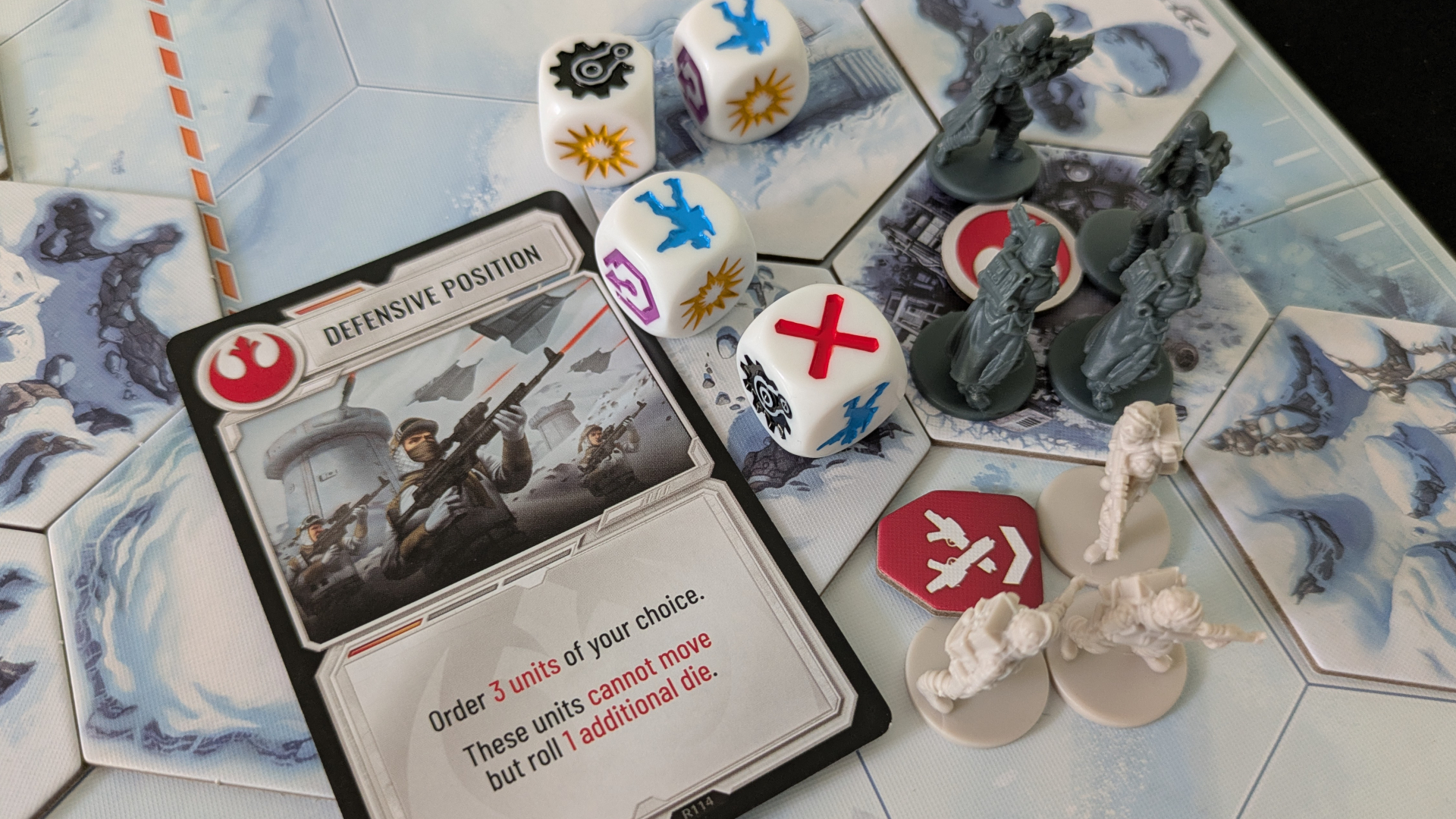 Battle of Hoth miniatures, dice, tokens, and cards laid out on a icy board