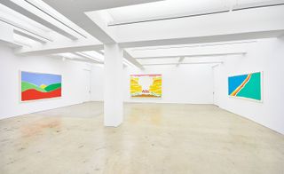 Large white studio with 3 colourful prints on the walls
