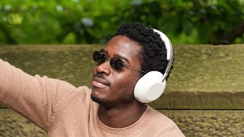 British actor Damon Idris wearing a pair of as-yet-unannounced Sony headphones and waving.