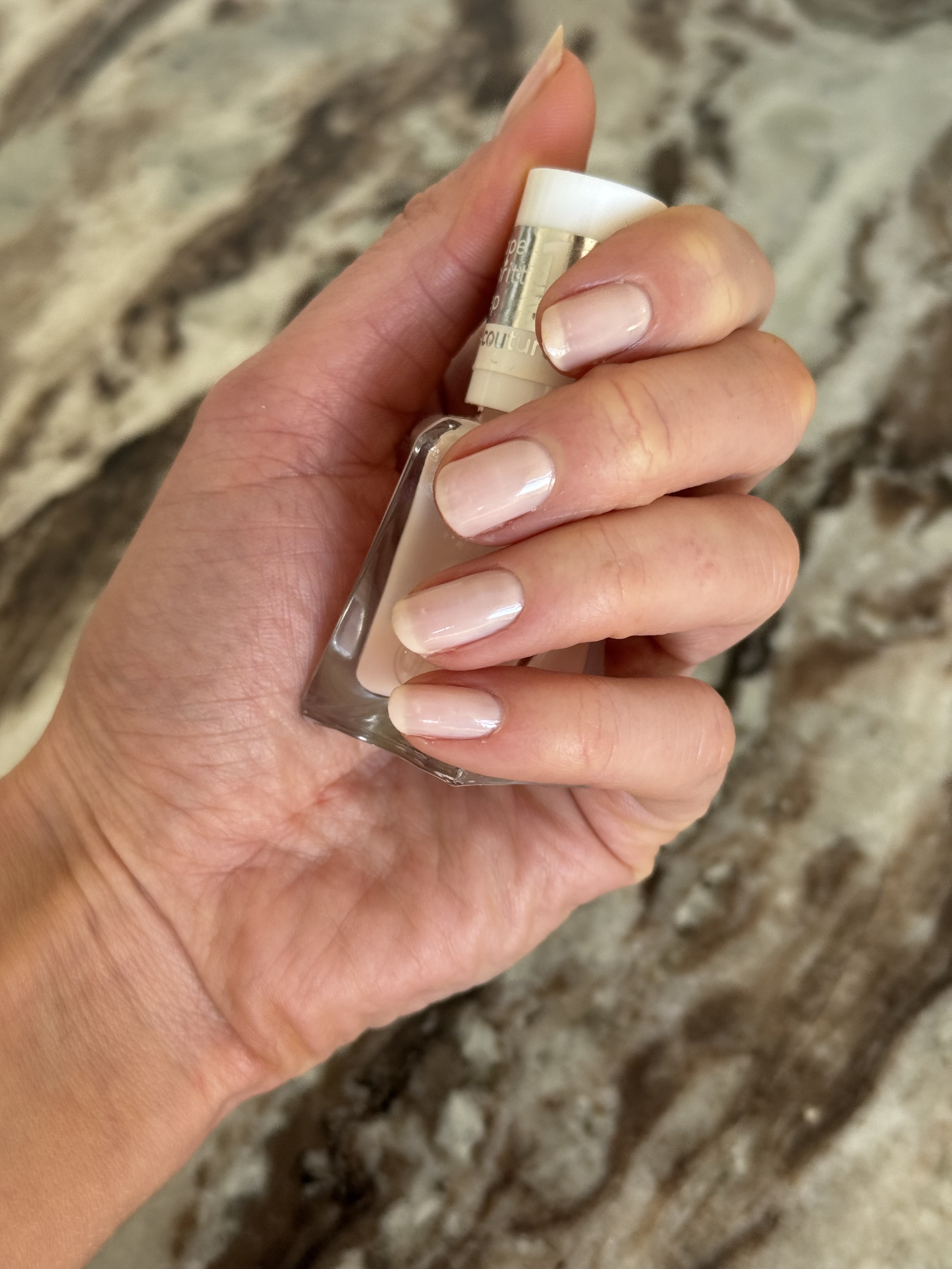 Eleanor wearing Essie Fairy Tailor on her nails and holding a bottle of nail polish