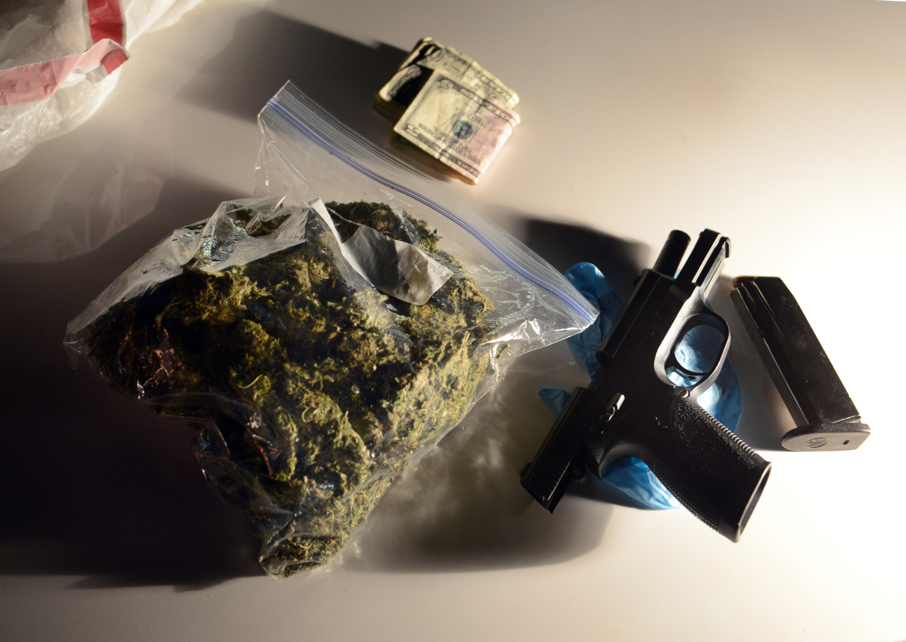Money, marijuana, and a .40 caliber handgun sit on the hood of a PG County police car after being confiscated on Thursday, April 25, 2013, in Landover, Maryland