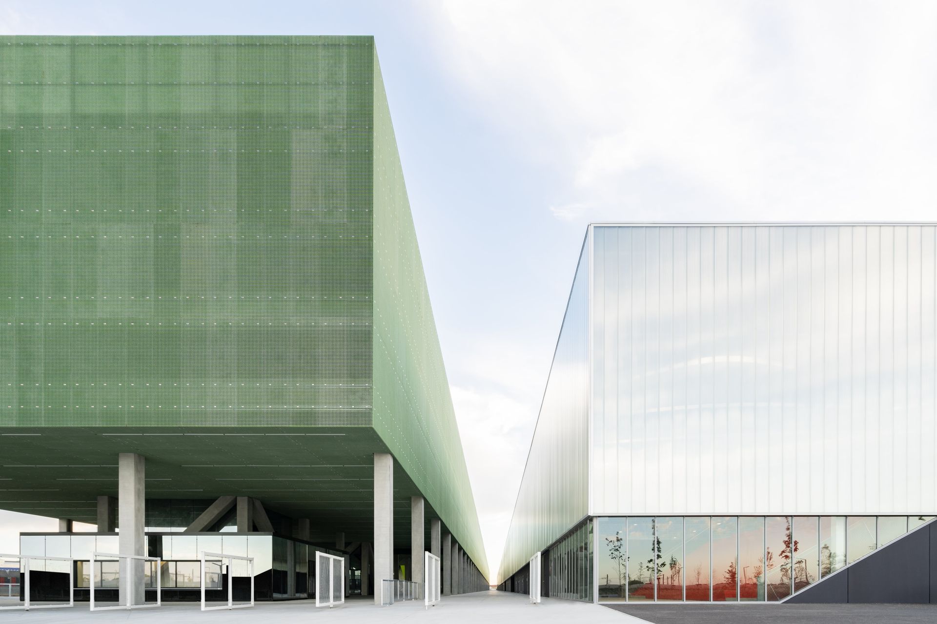 Exhibition complex with two buildings one next to the other. Both are rectangular-shaped. The one to the left is green, and the one to the right is white.